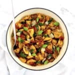 overhead view of Creamy Tuscan Tortellini in white skillet with serving spoon