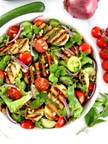 Grilled Halloumi Salad in white bowl with vinaigrette on top
